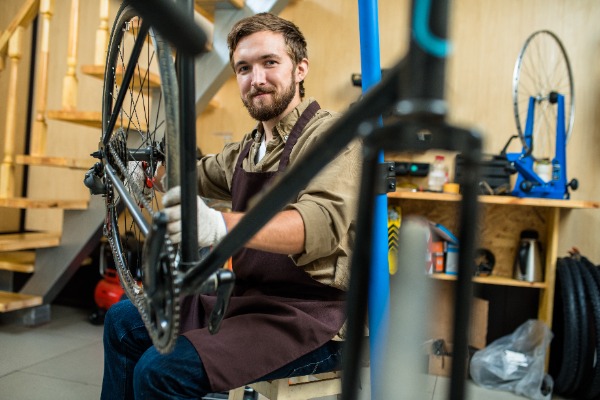 Jeune homme répare un vélo